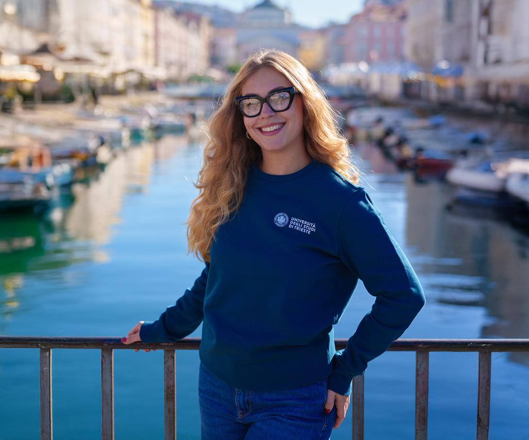 studentessa con felpa girocollo blu. sullo sfondo il canale di Ponterosso