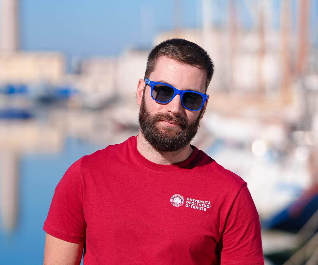 studente con occhiali da sole blu UniTS